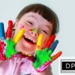 A joyful child with Down Syndrome displaying colorful paint on their hands, representing the inclusive rights and educational support for special needs in Georgia. The Disable Persons Health Organization (DP HO) logo is visible in the bottom right corner.