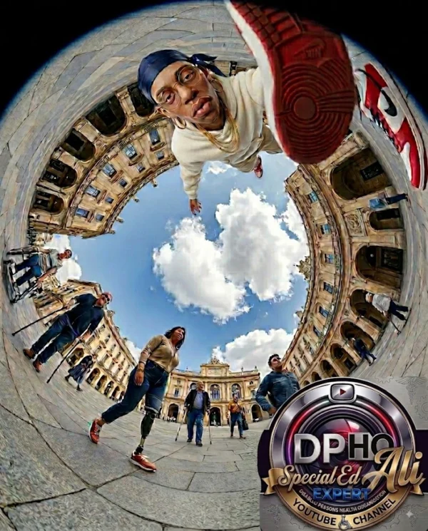 A dramatic 360-degree fish-eye perspective photograph set in an expansive, historic cobblestone plaza surrounded by classic European-style architecture under a blue sky with fluffy white clouds. At the top of the spherical frame, a young man wearing a blue du-rag, glasses, a gold chain, and a cream-colored tracksuit leans directly into the camera lens, extending a red and white sneaker prominently into the foreground. Moving clockwise around the circular frame, diverse individuals with disabilities are captured navigating the plaza, including a woman walking with a high-performance prosthetic leg and a man walking with crutches. The bottom-right corner features a circular custom metallic emblem combining the DPHO (Disabled Persons Health Organization) and Special Ed Expert Ali YouTube Channel logos.